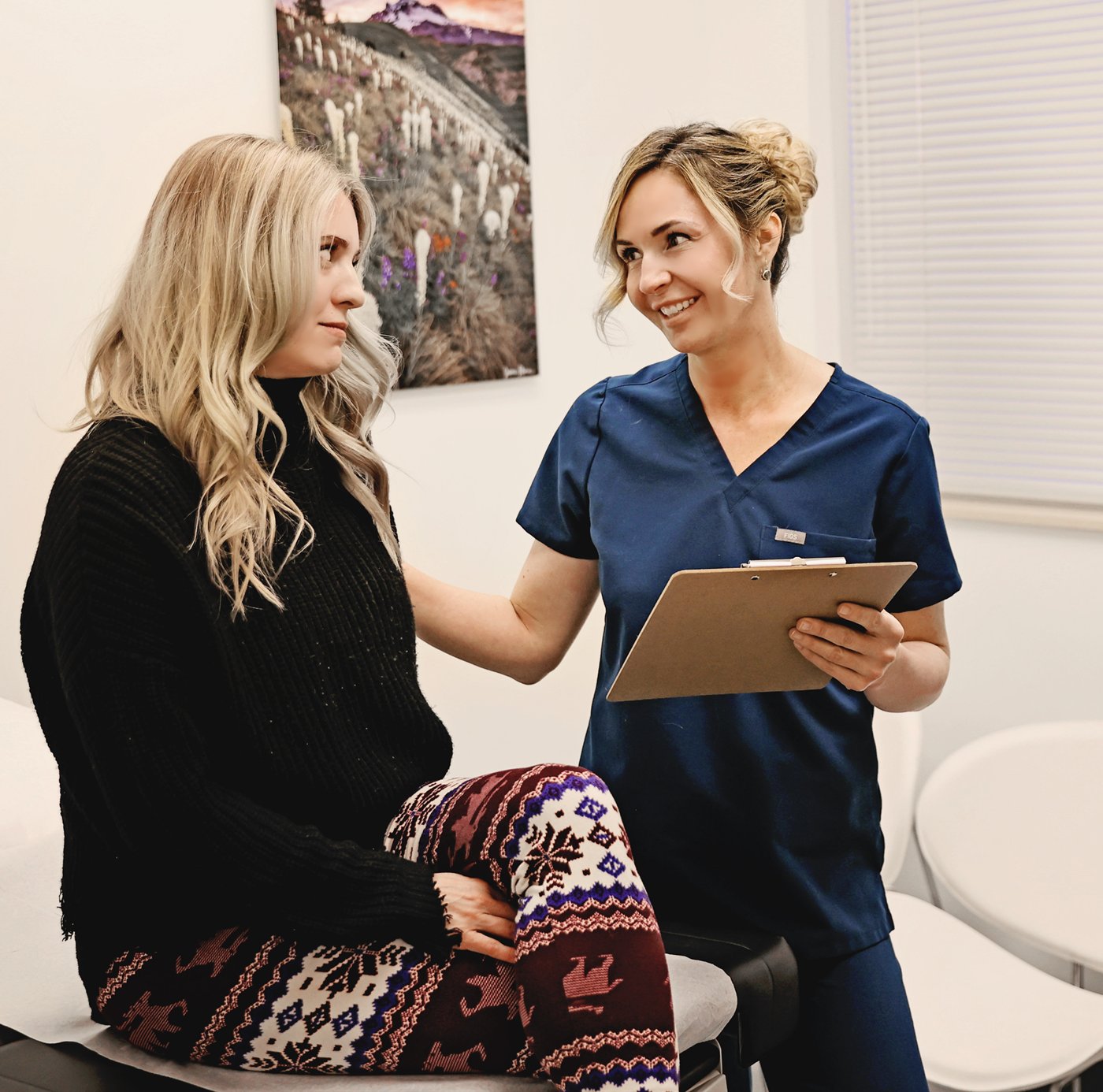 Dr. Karla Pivik discussing an acne treatment plan with a patient at Juniper Dermatology in the exam room