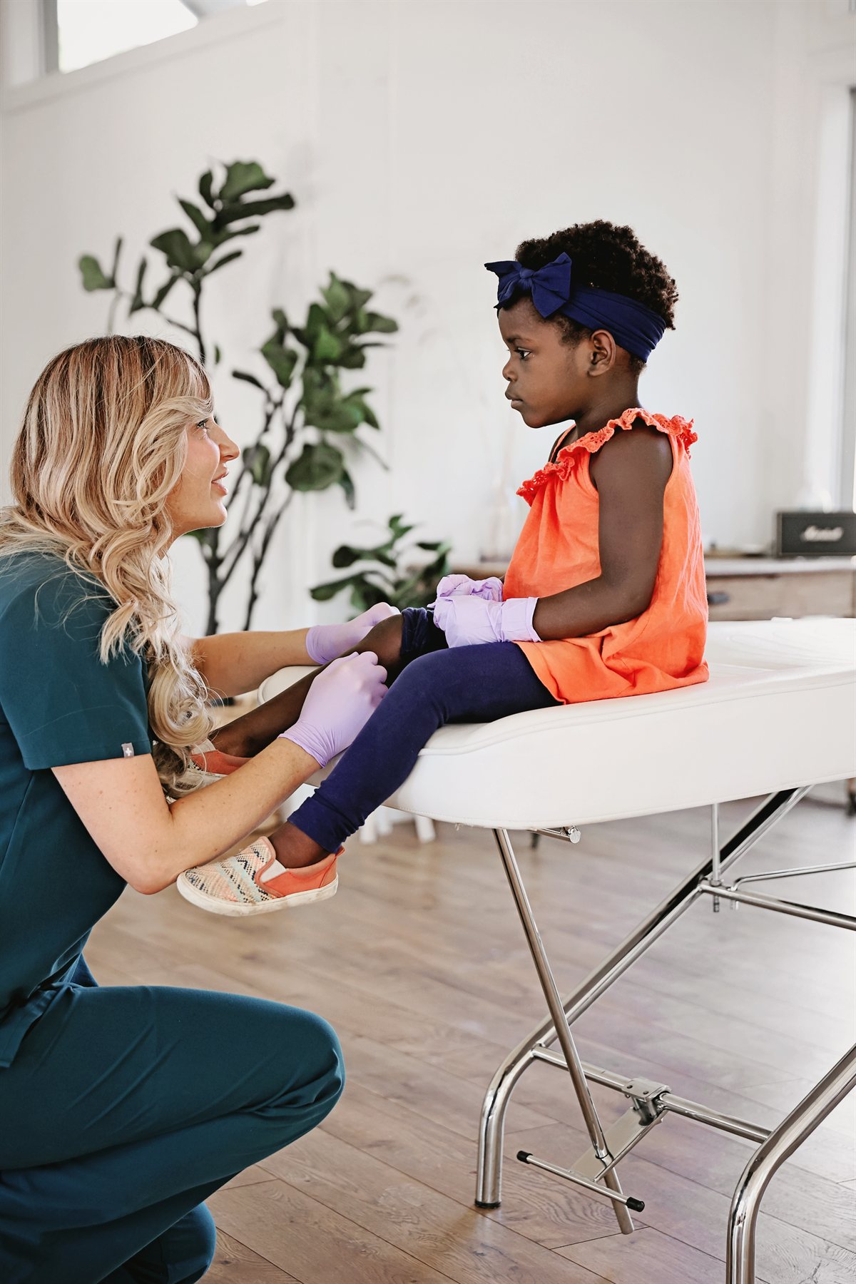 Dr. Pivik of Juniper Dermatology examining a child's leg during a skin visit in Bend, Oregon