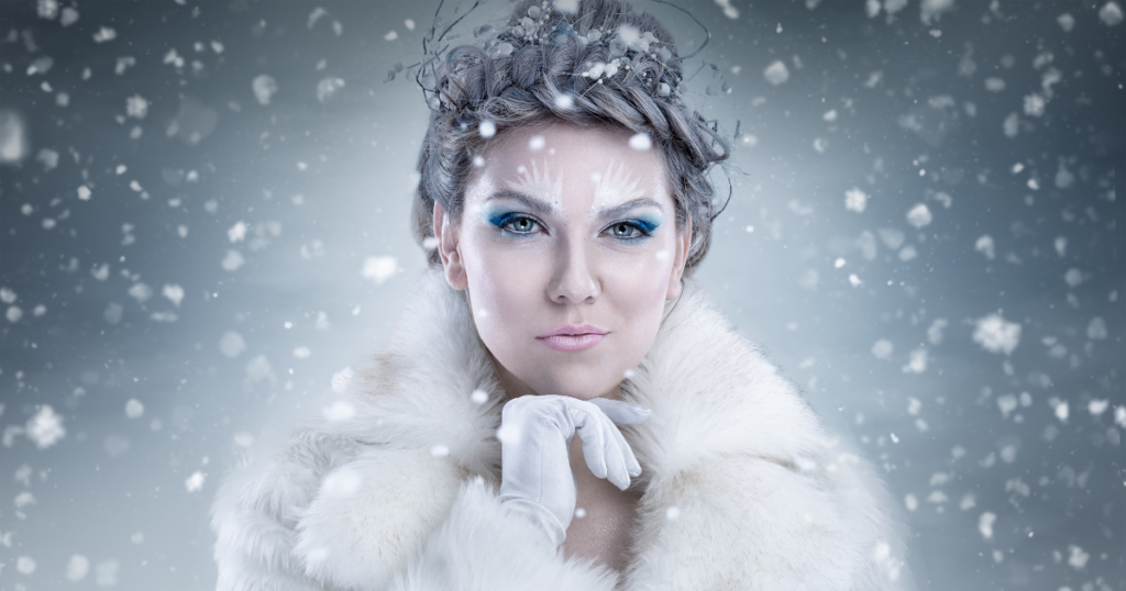 Woman covered in snow and winter makeup.