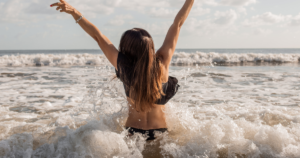 Woman splashing in the waves at the beach.