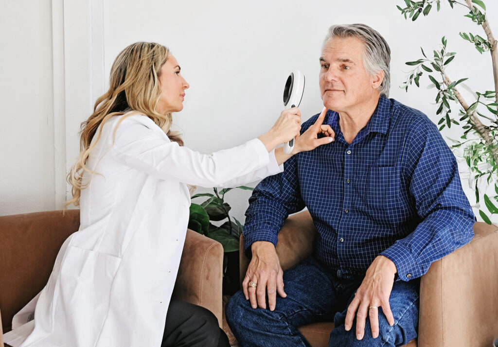 Dermatologist examining patient's skin prior to VBeam laser treatment in Bend